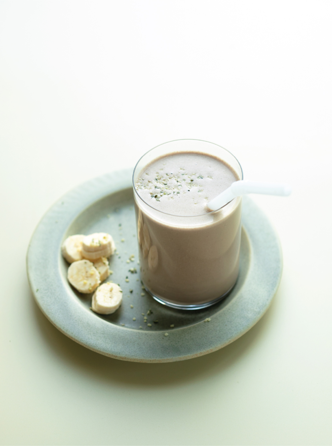 a glass of chocolate peanut butter protein shake on a green plate 