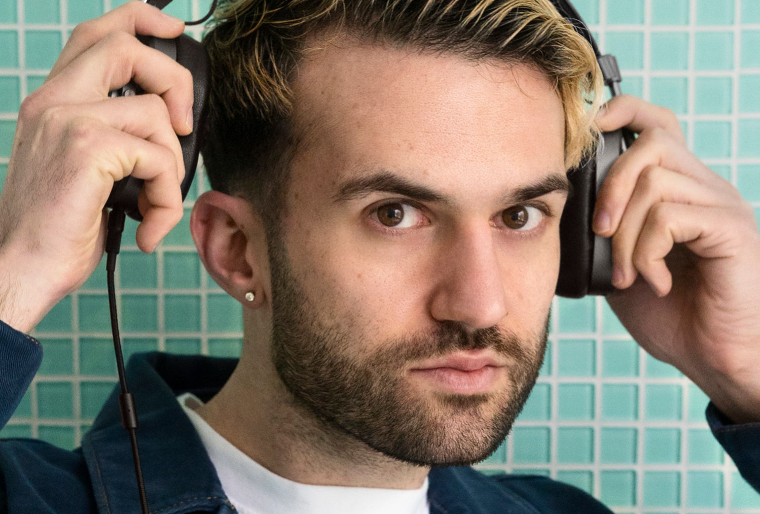 Lifestyle image of DJ A-Trak wearing Master and Dynamic headphones