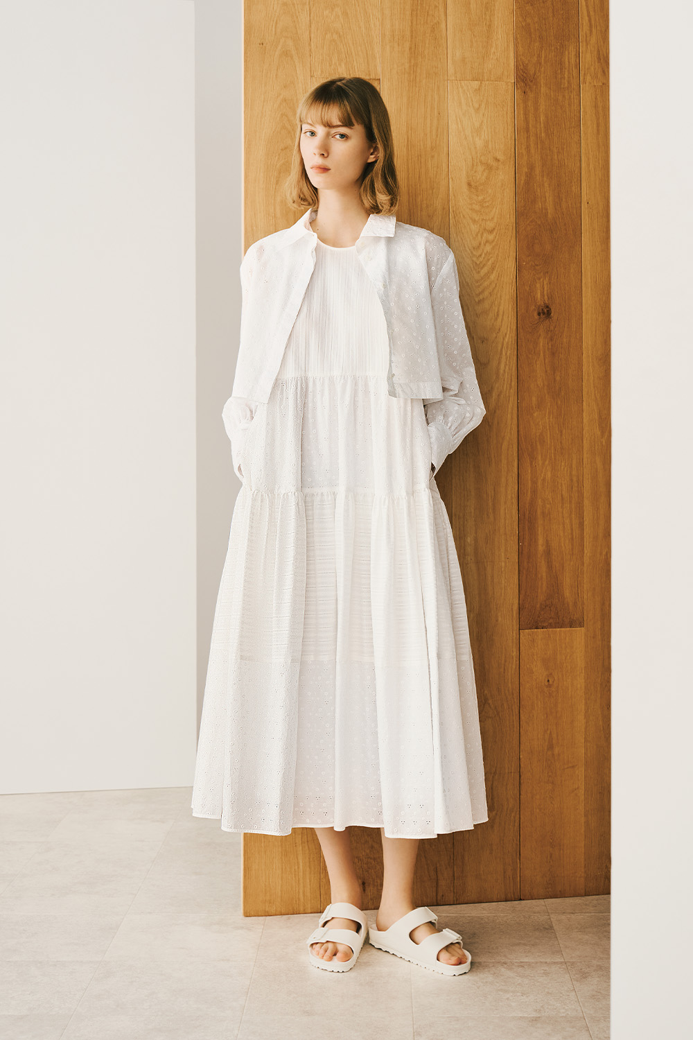  A woman is wearing a white blouse on a flowing white dress