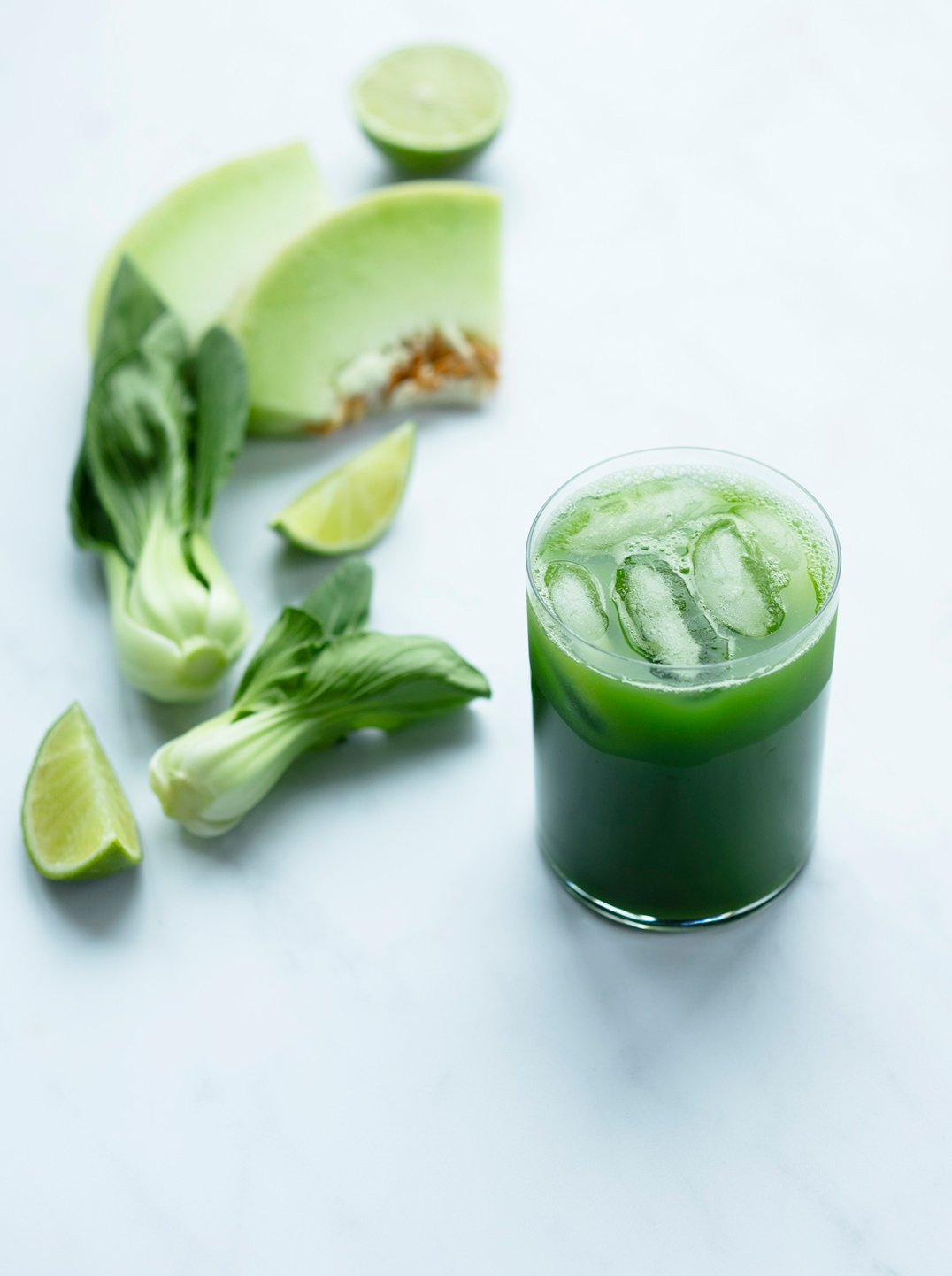 a glass of bright bok-choy juice with ingredients