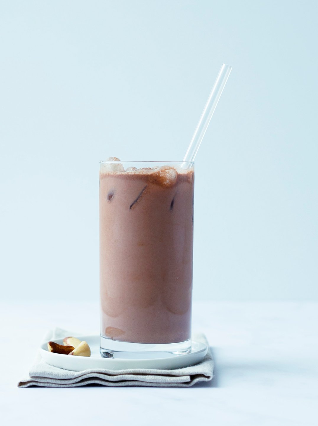 A tall glass of energize milk with a glass straw