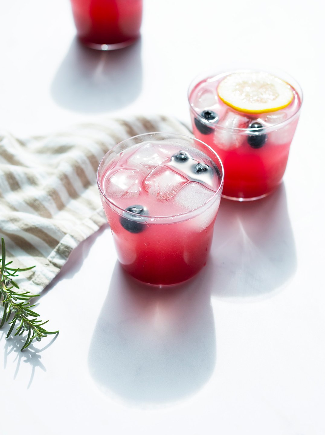 two glasses of blueberry green tea spritzer with ice and blueberries