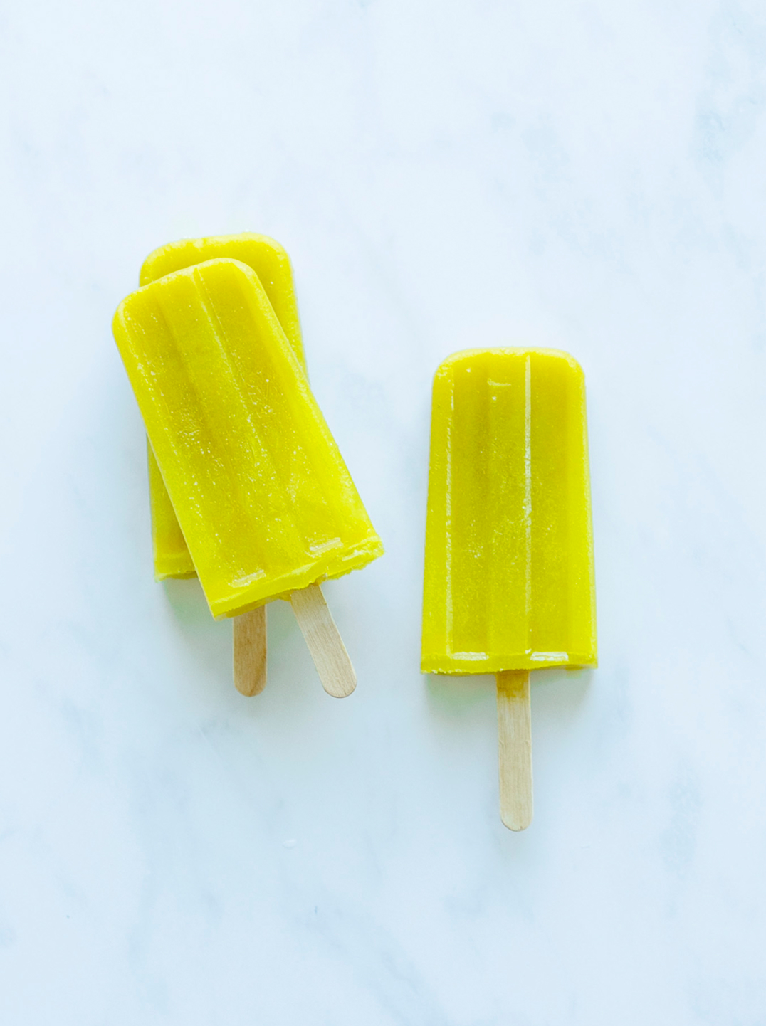 3 Golden Pineapple Pops on a marble surface