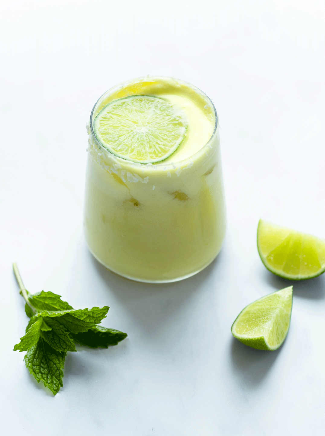 glass of piña colada with mint and lime