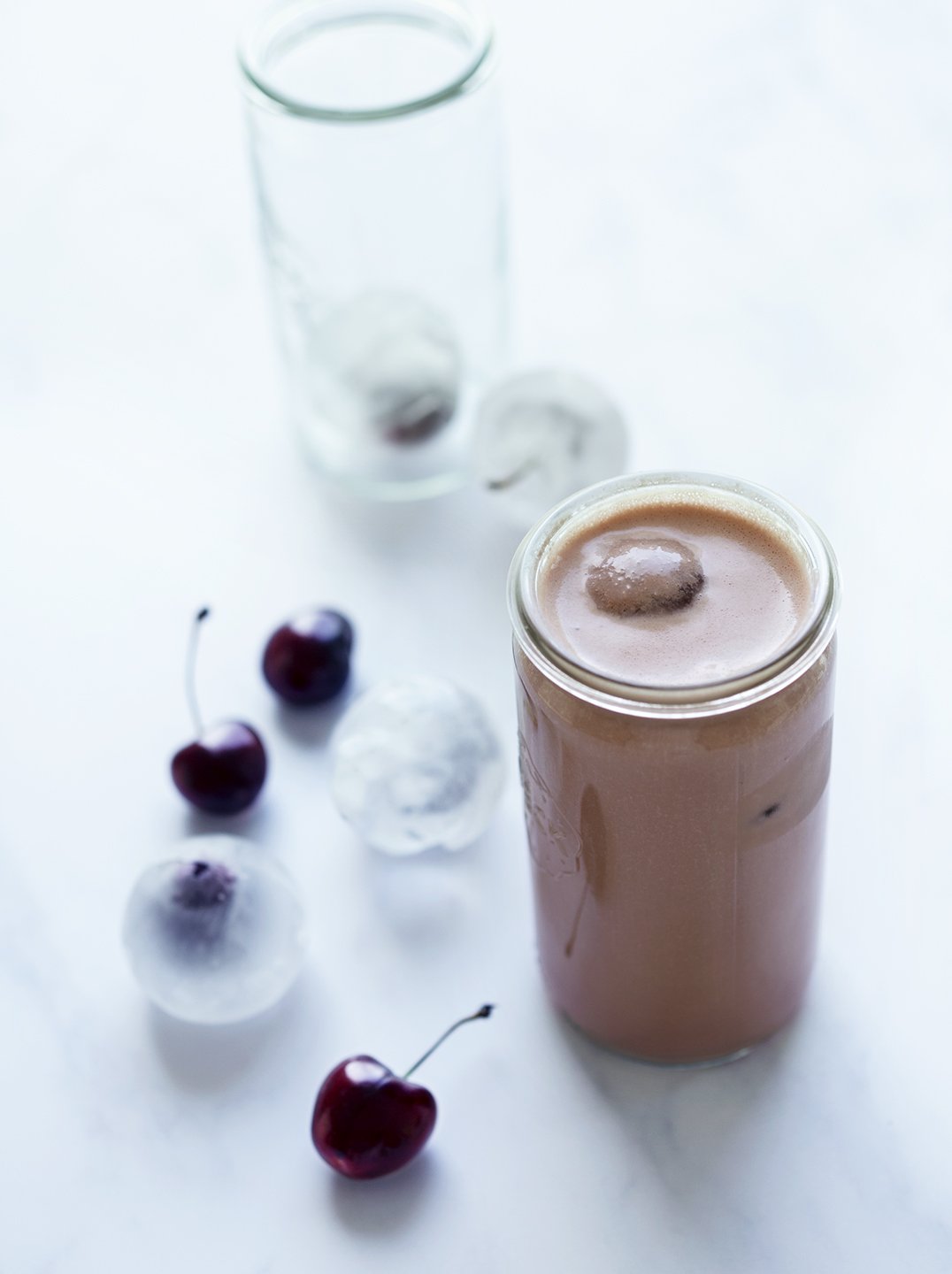 a glass of choco cherry bliss with frozen cherries