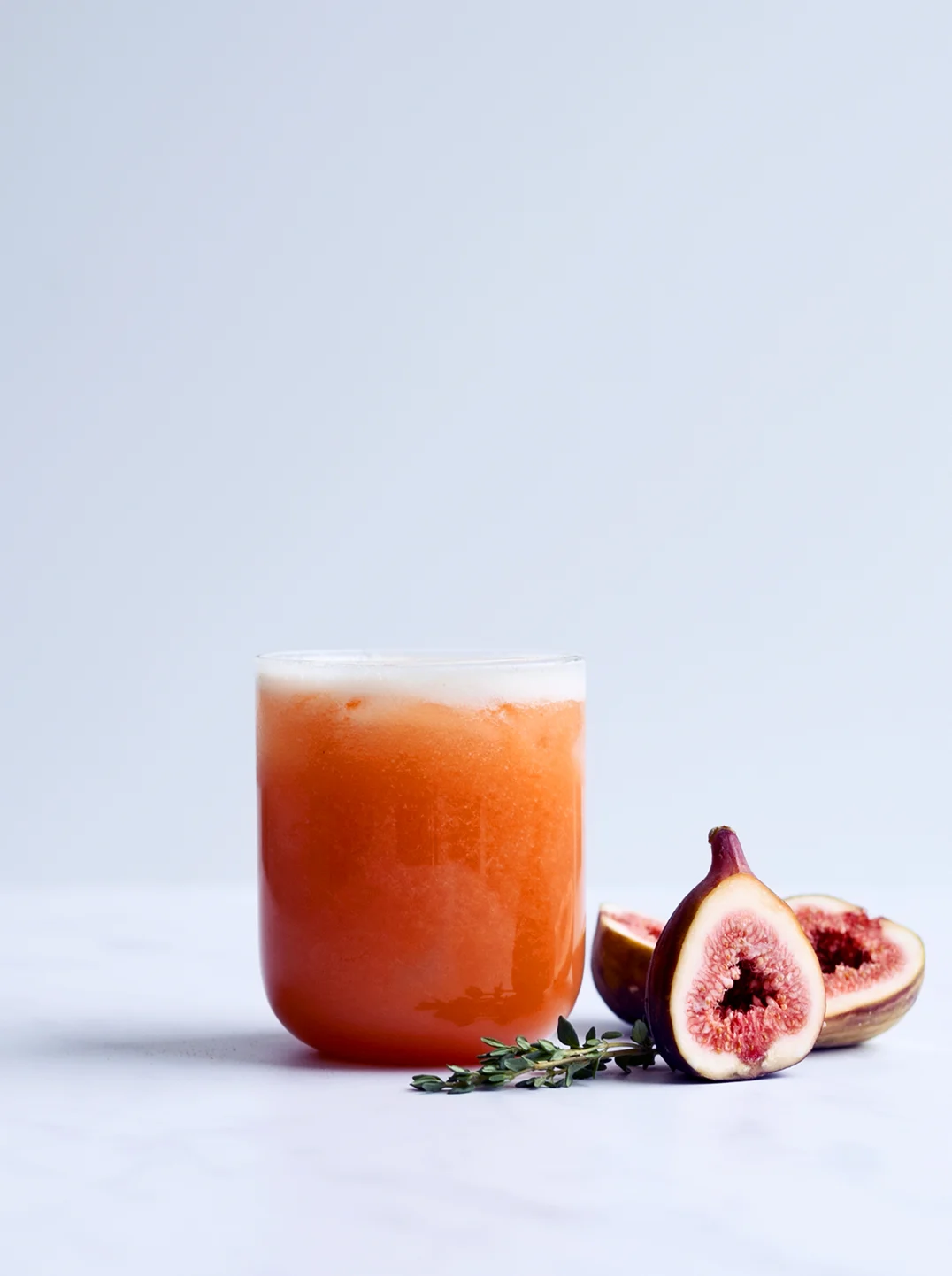 a glass of autumn fig juice with a fresh fig 