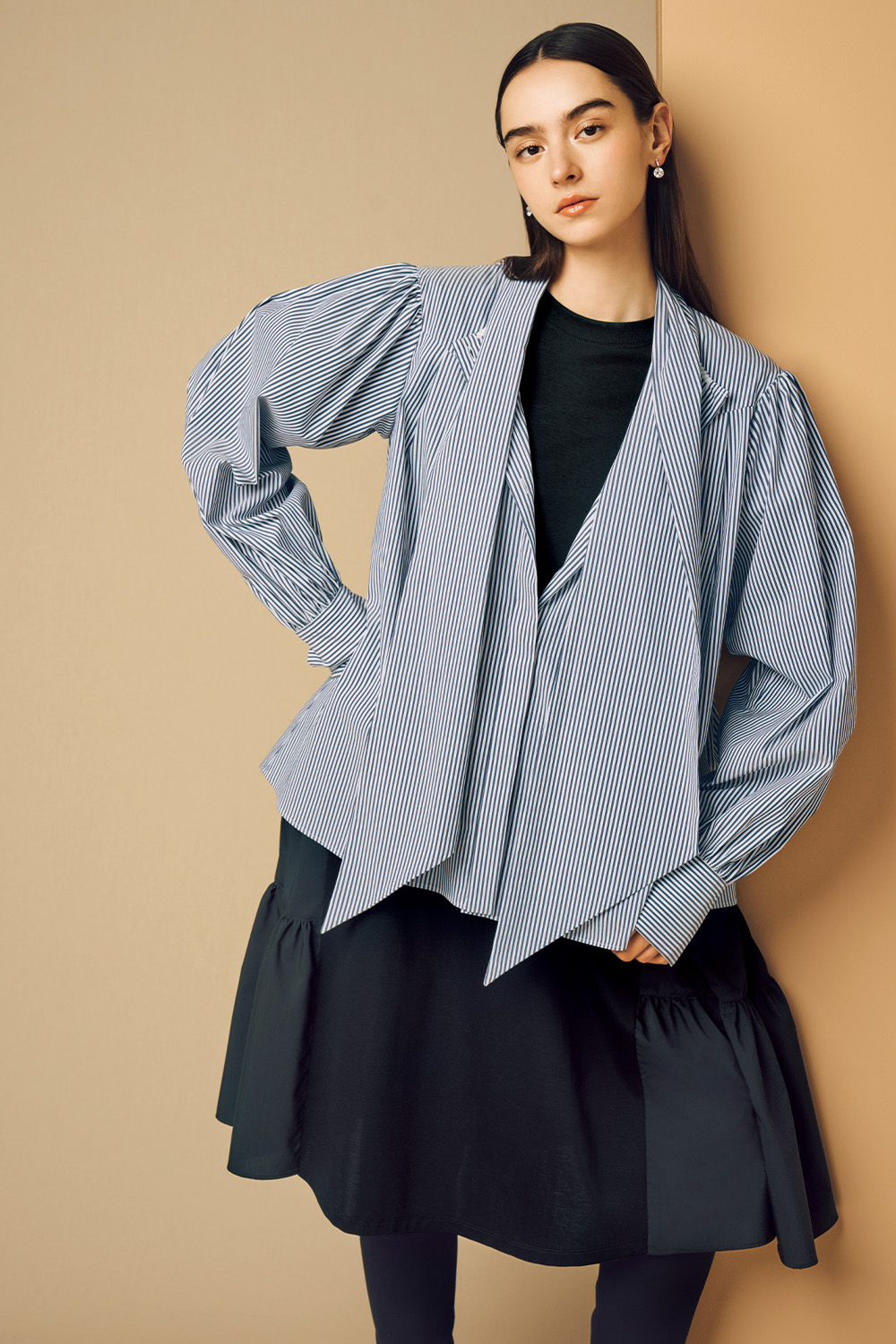 Model is wearing a black striped top on a black dress.