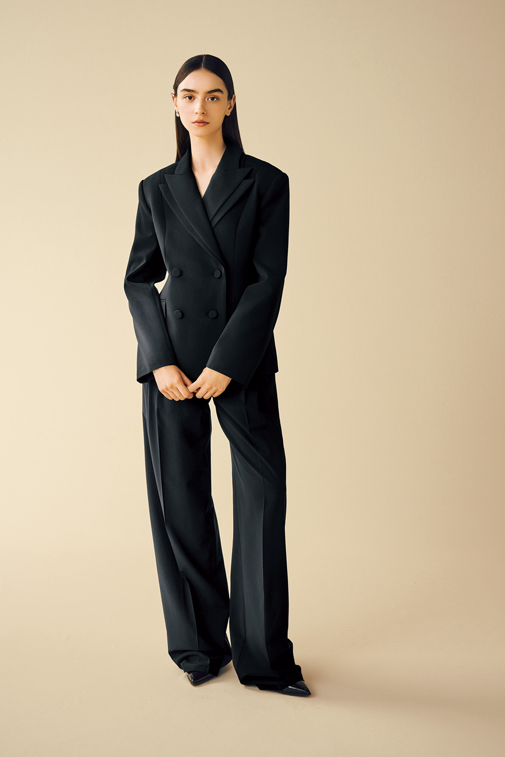 Model is wearing a black jacket and pants.