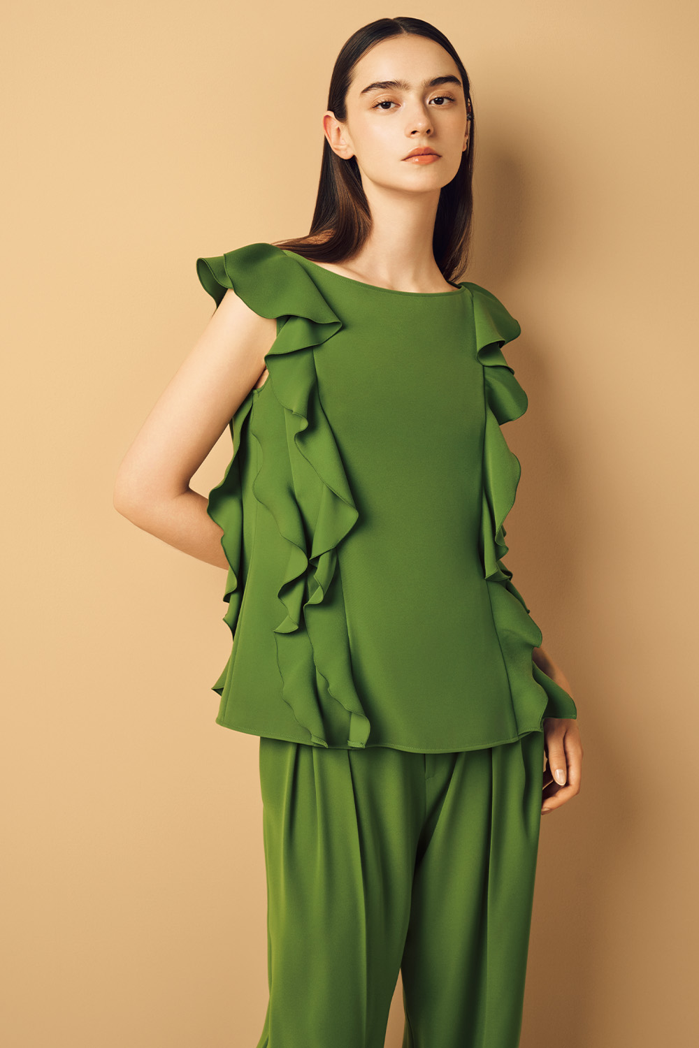 Model is wearing a stylish green top paired with matching green pants.