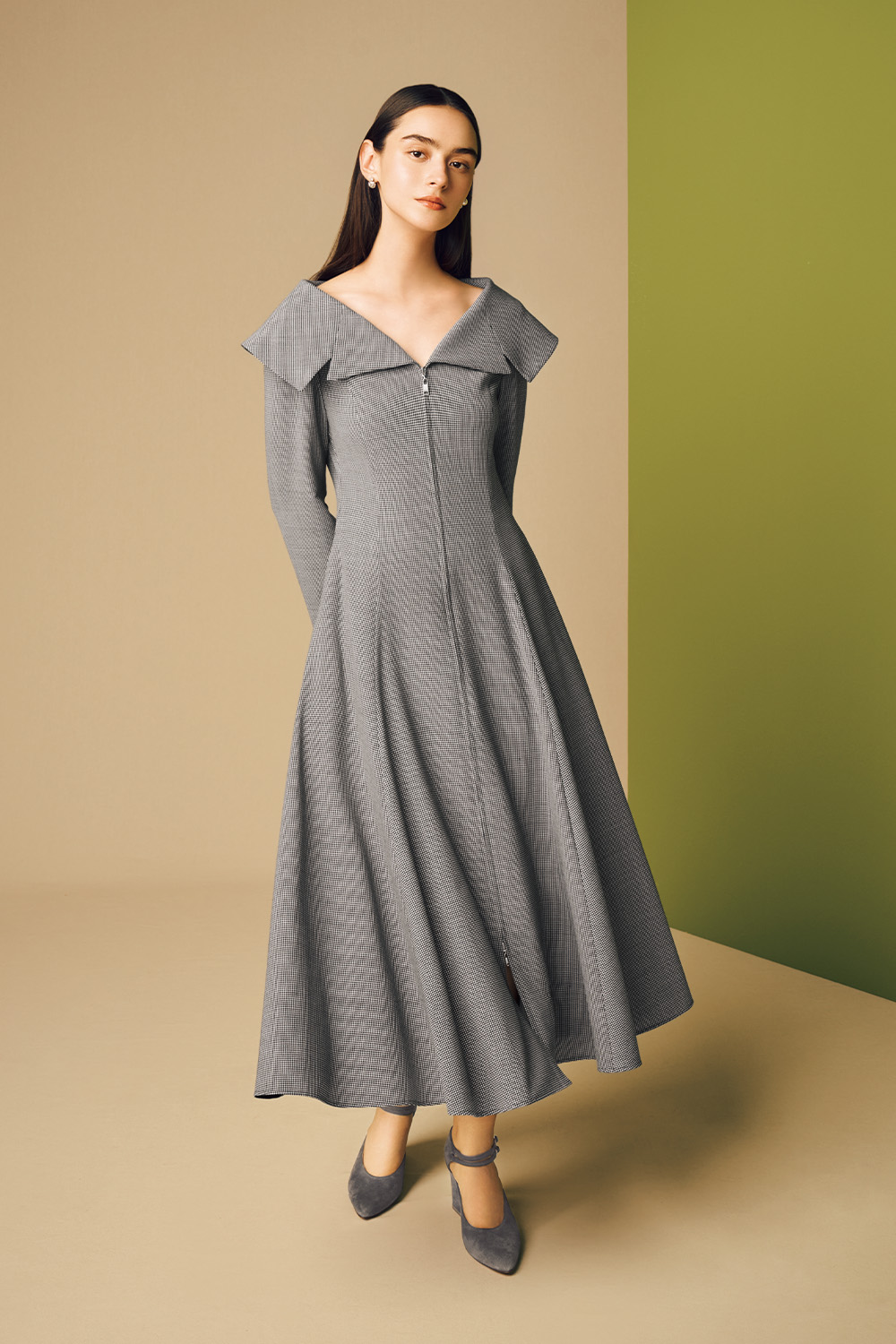 Model is wearing a grey dress and heels.