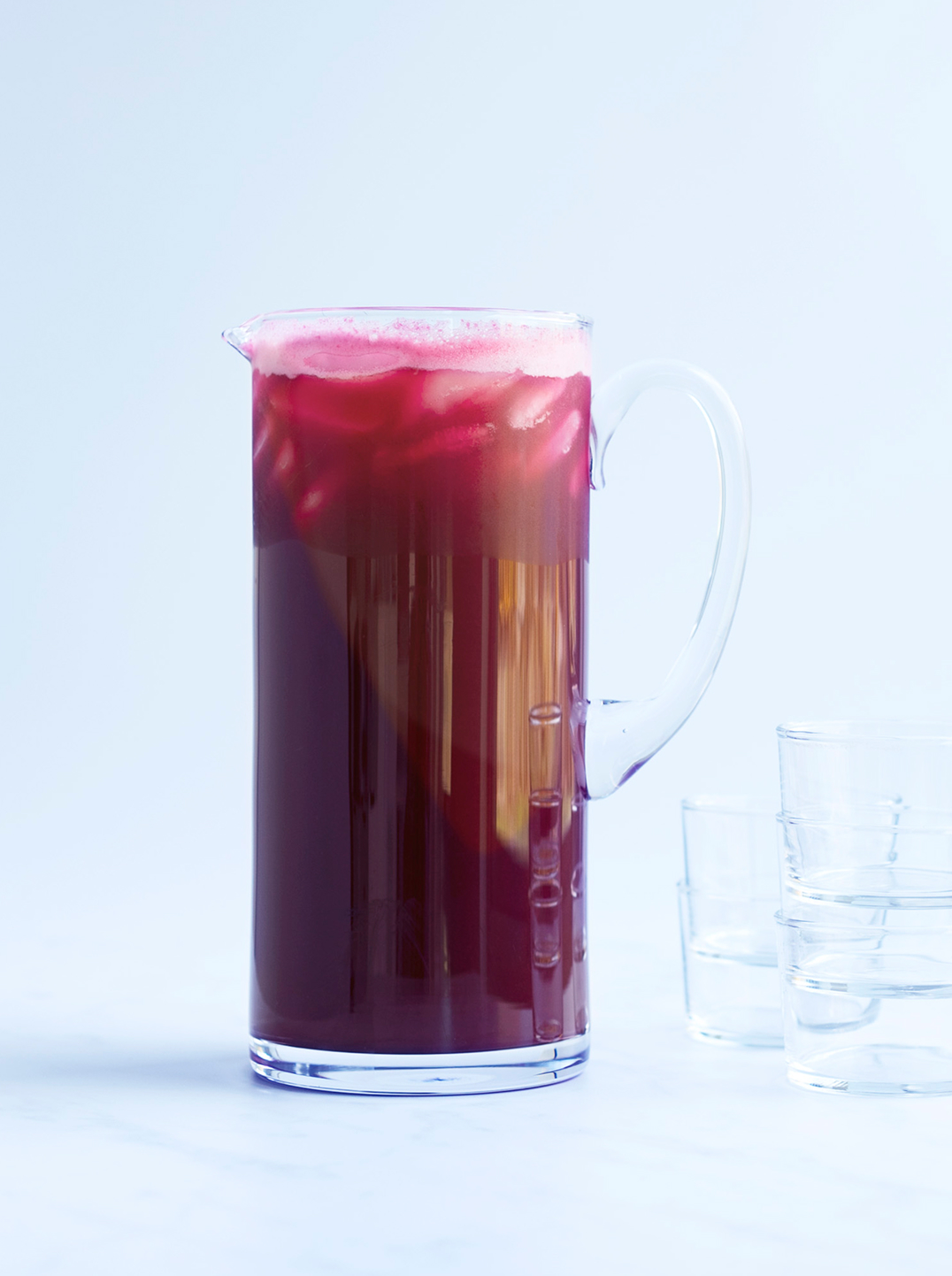 A tall glass pitcher of deep red happy heart juice 