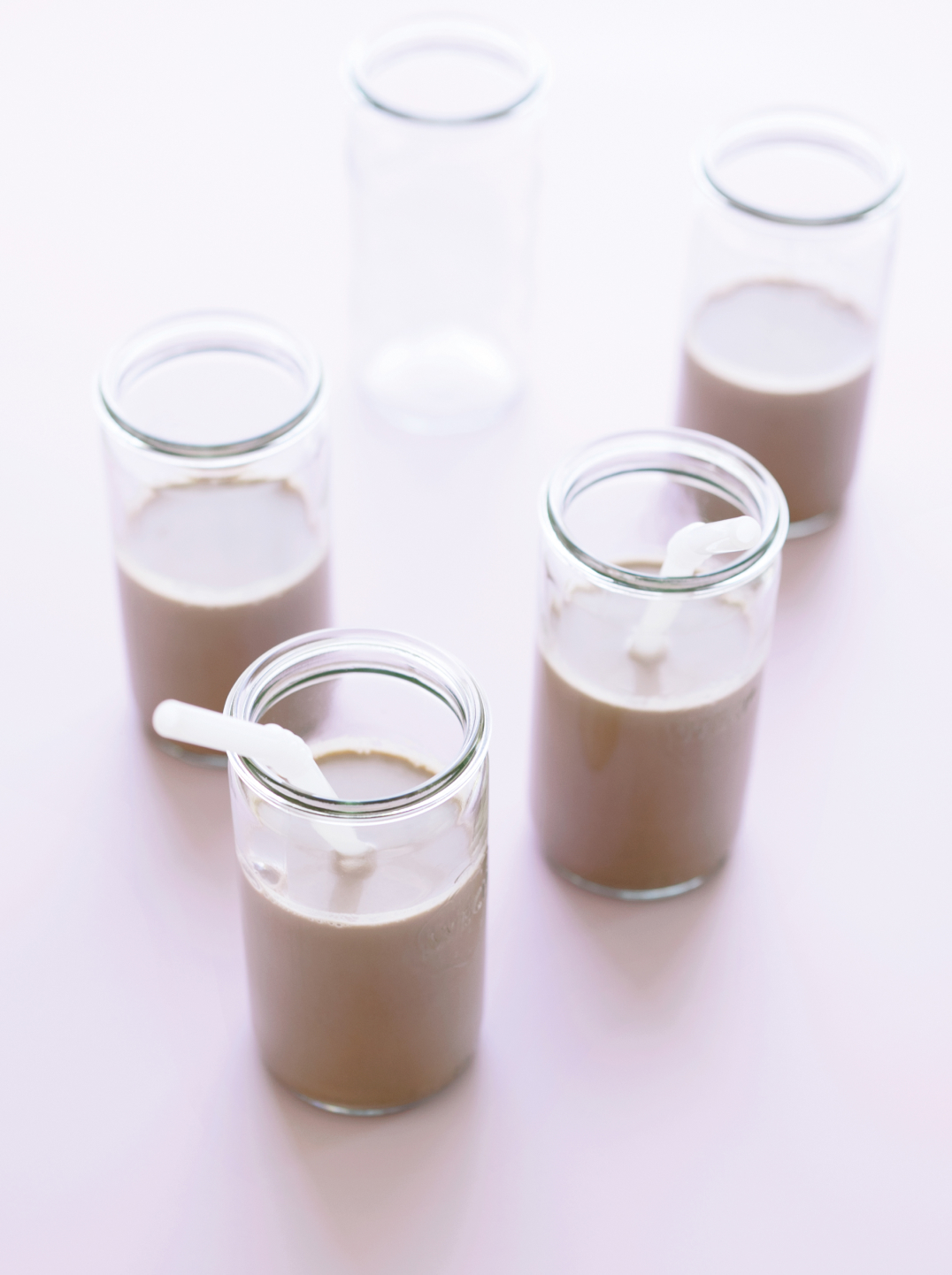 Four glasses of Chocolate  Hazelnut Milk on a lavender background