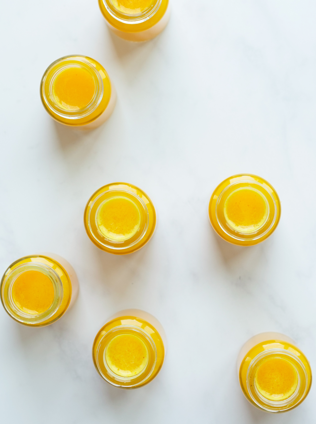 two glasses of banana oat milk garnished with banana slices