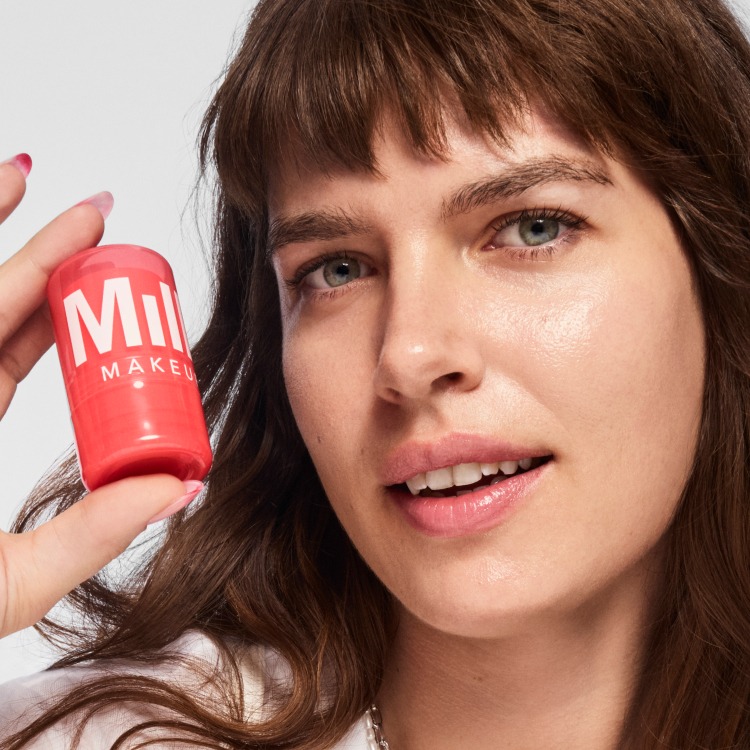 A model holds up Milk Makeup Watermelon Jelly Glow Serum