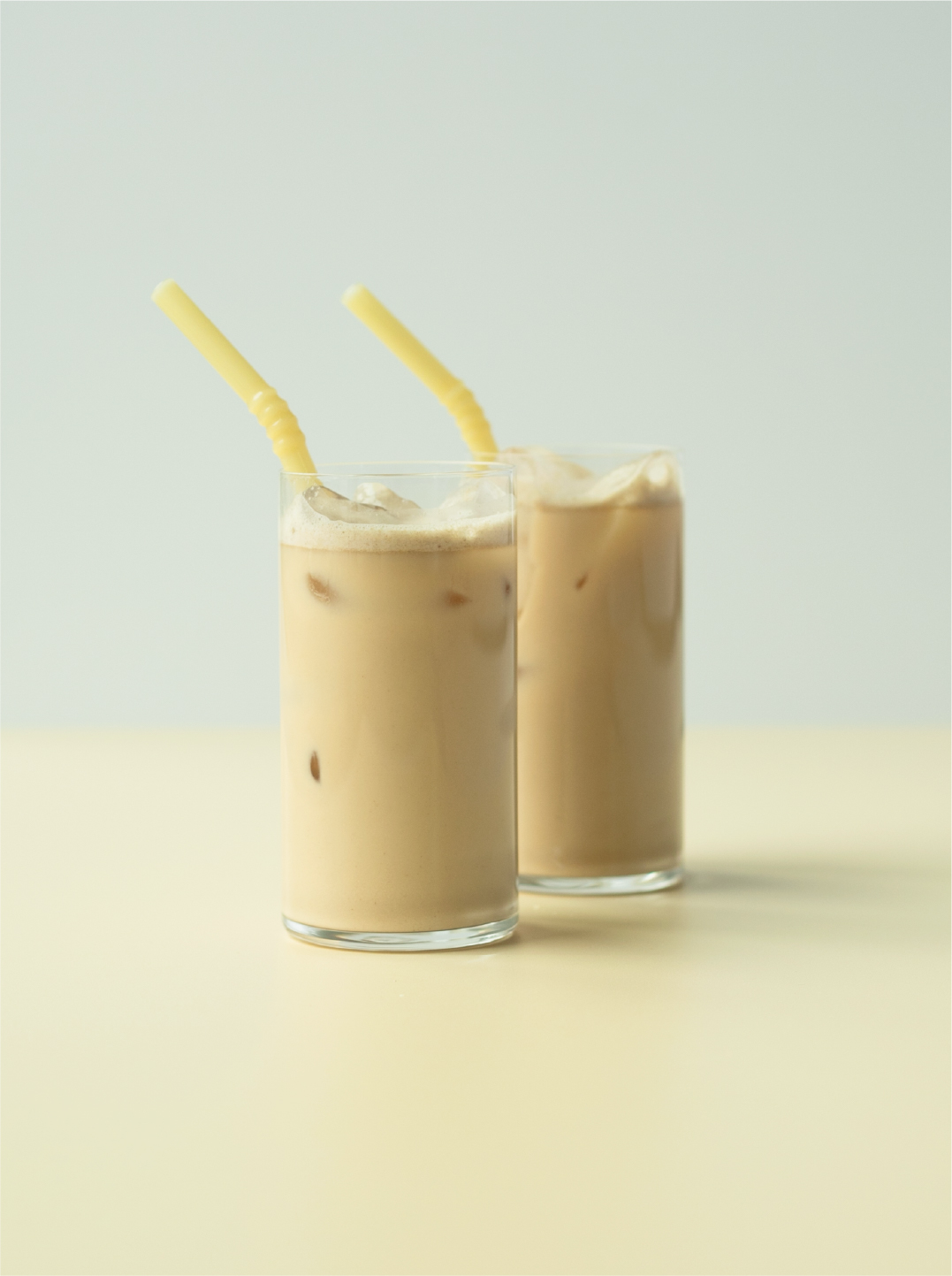 Two glasses with yellow straws and chai