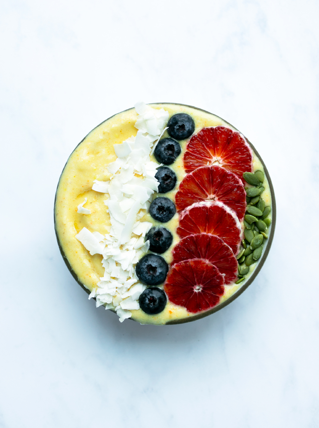 A golden wellness bowl on a marble background