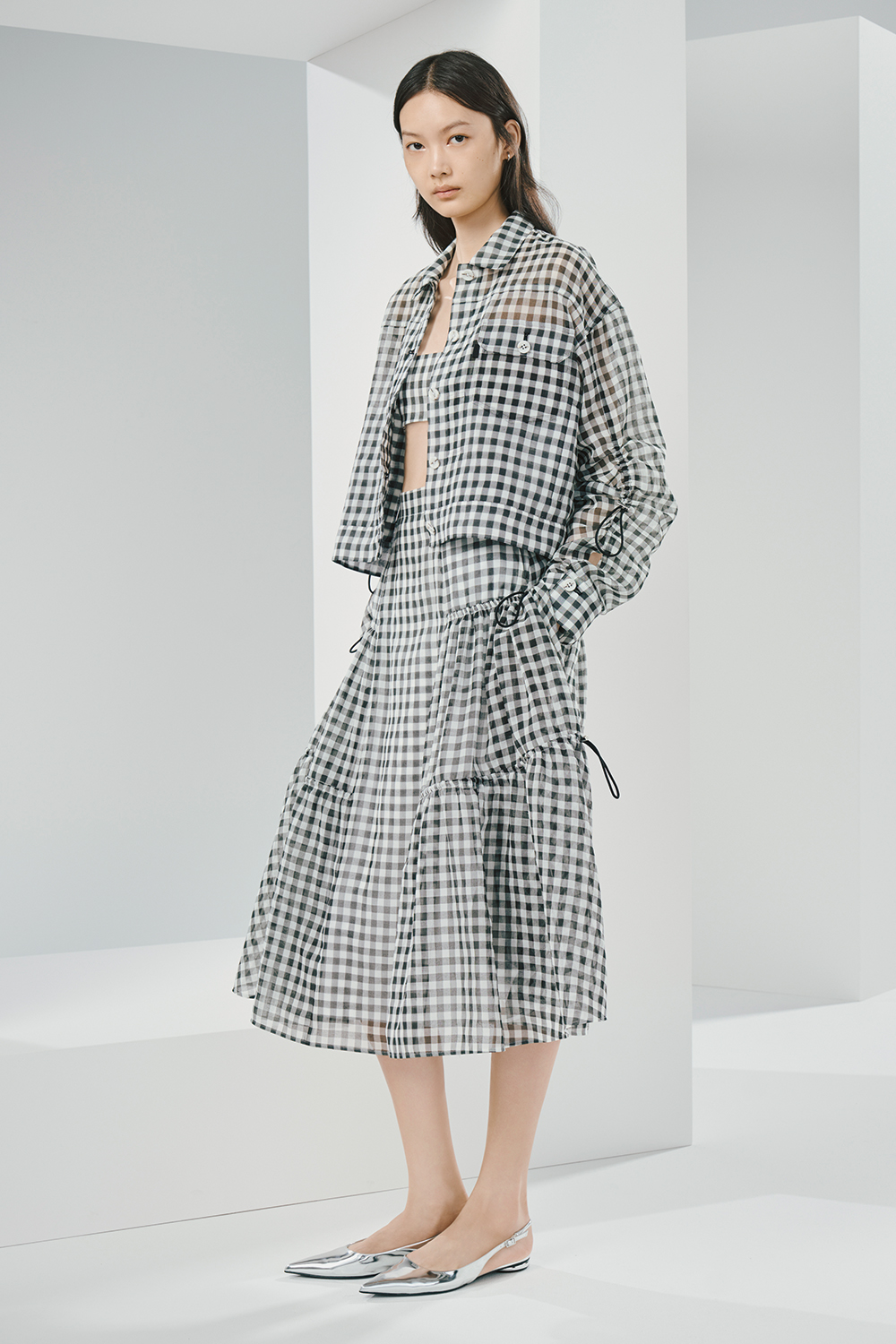 Model is wearing a stylish black and white checkered jacket and a matching skirt.