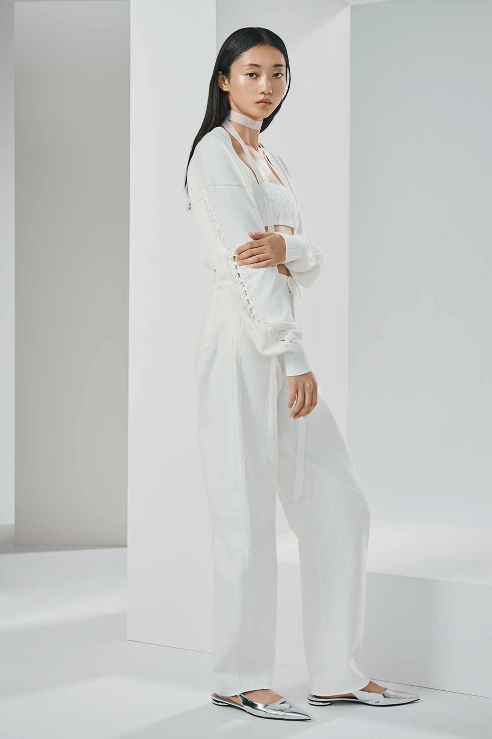 Model is wearing a white knit bolero and pants.
