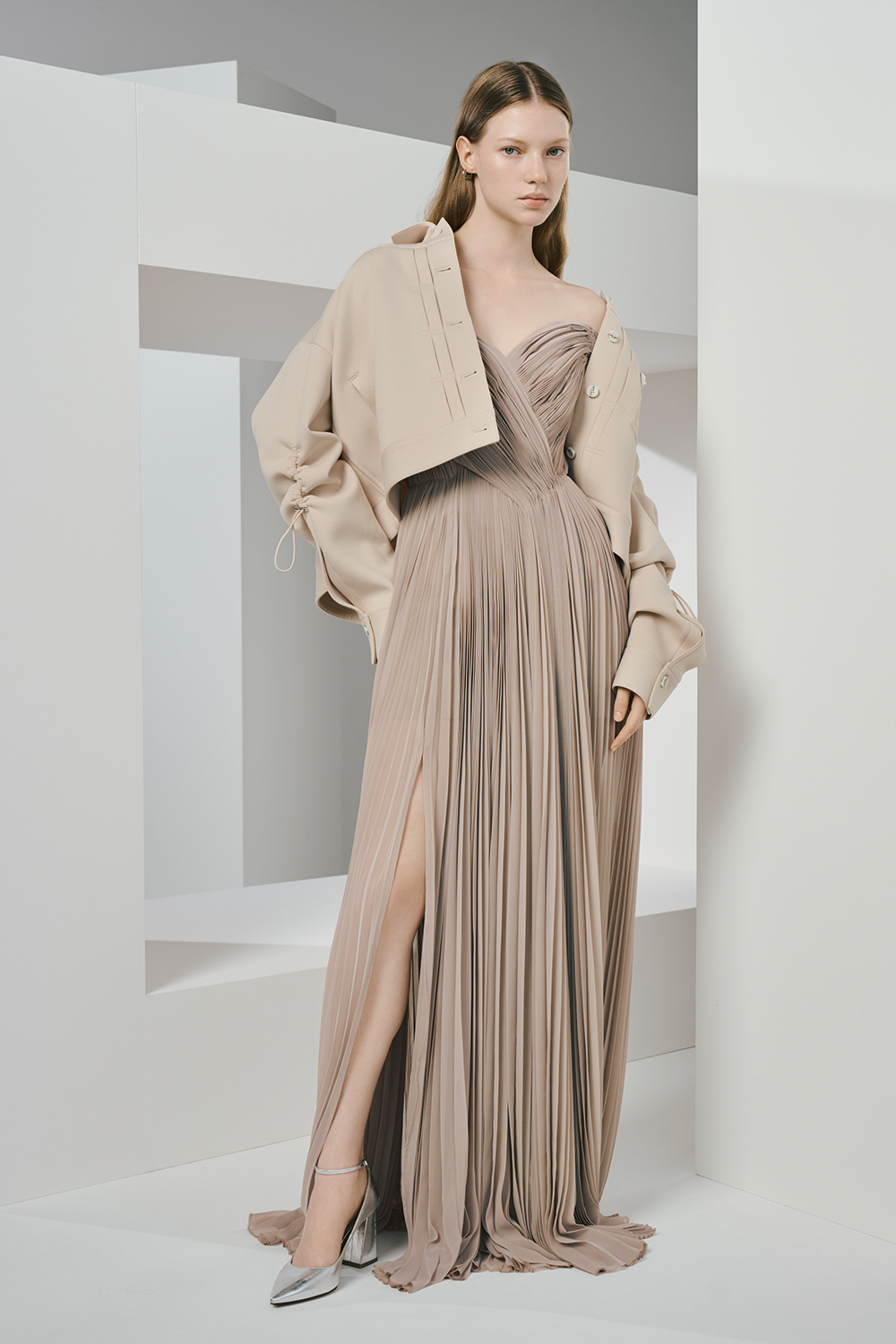 Model wearing a beige long dress paired with a stylish beige jacket.