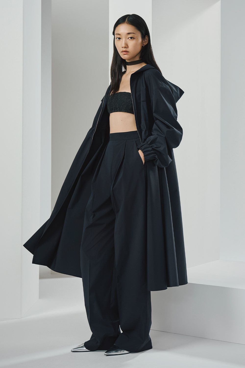 Model is wearing a black coat and matching pants.