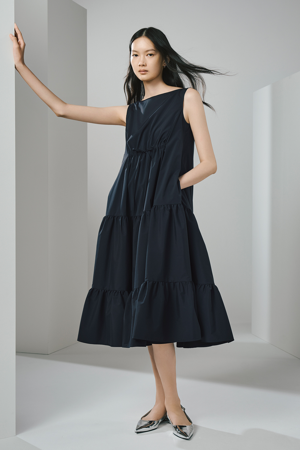 Model is wearing a black sleeveless dress.