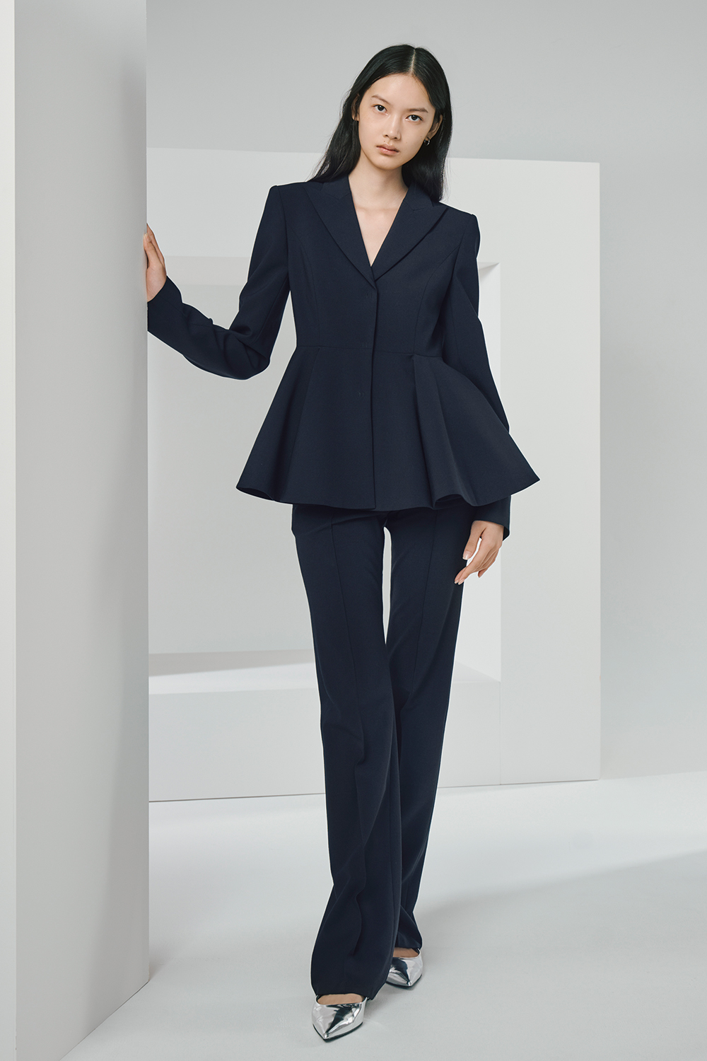 Model is wearing a dark navy jacket paired with matching pants.