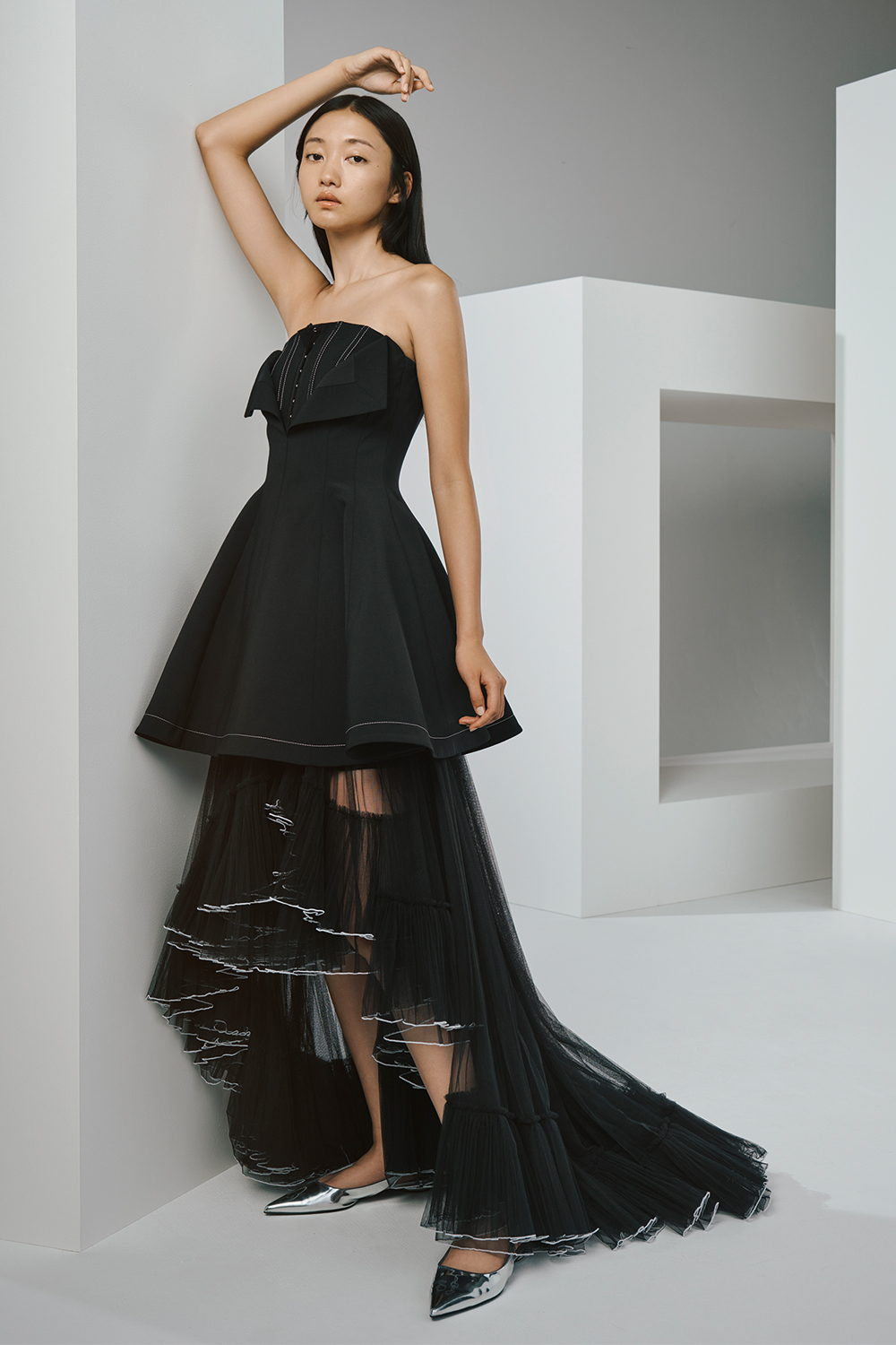 Model is wearing a black top and a black lace skirt.