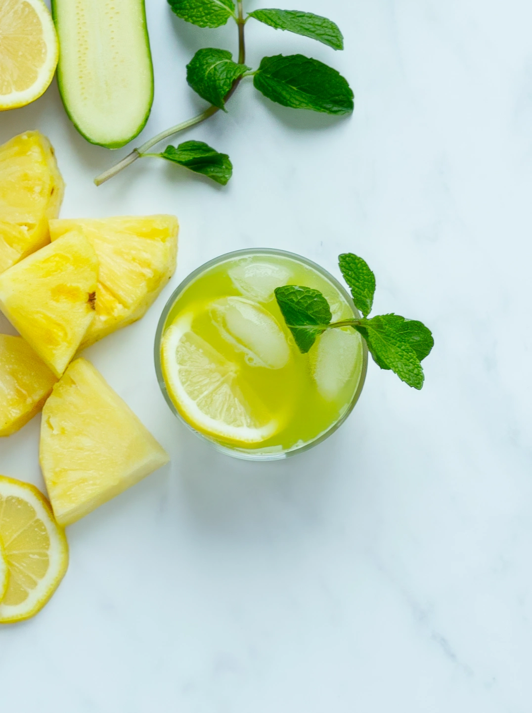 a glass of hydrating greens garnished with lemon and mint
