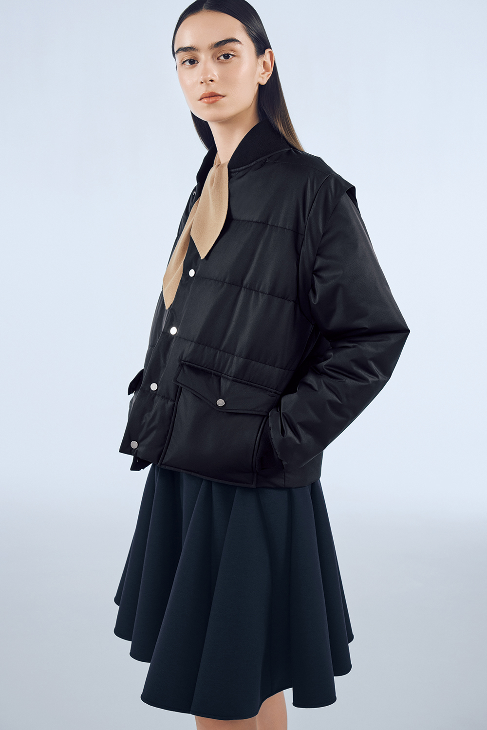 Model is wearing a dark navy skirt and a black jacket.