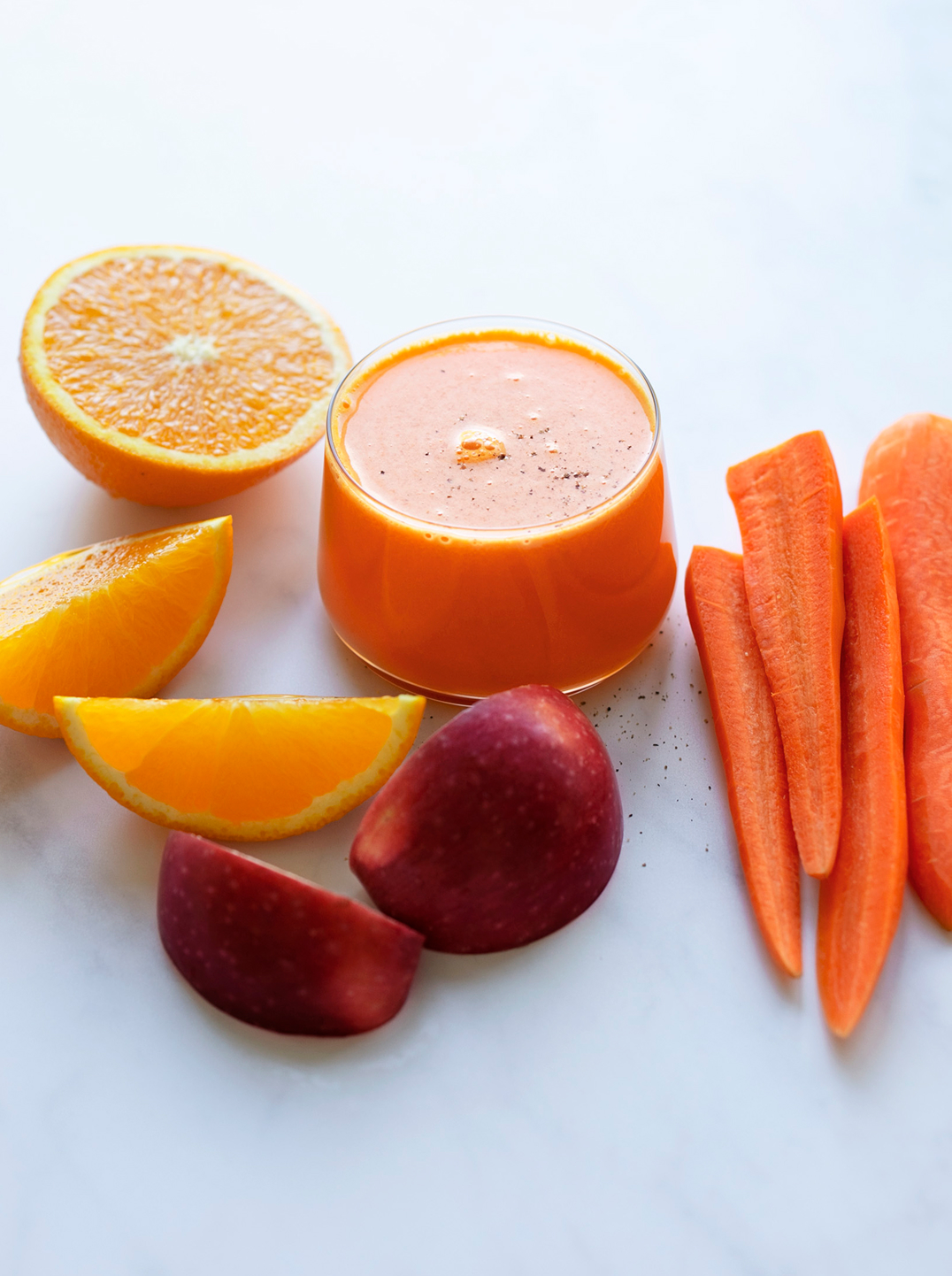A glass of root revival juice with ingredients