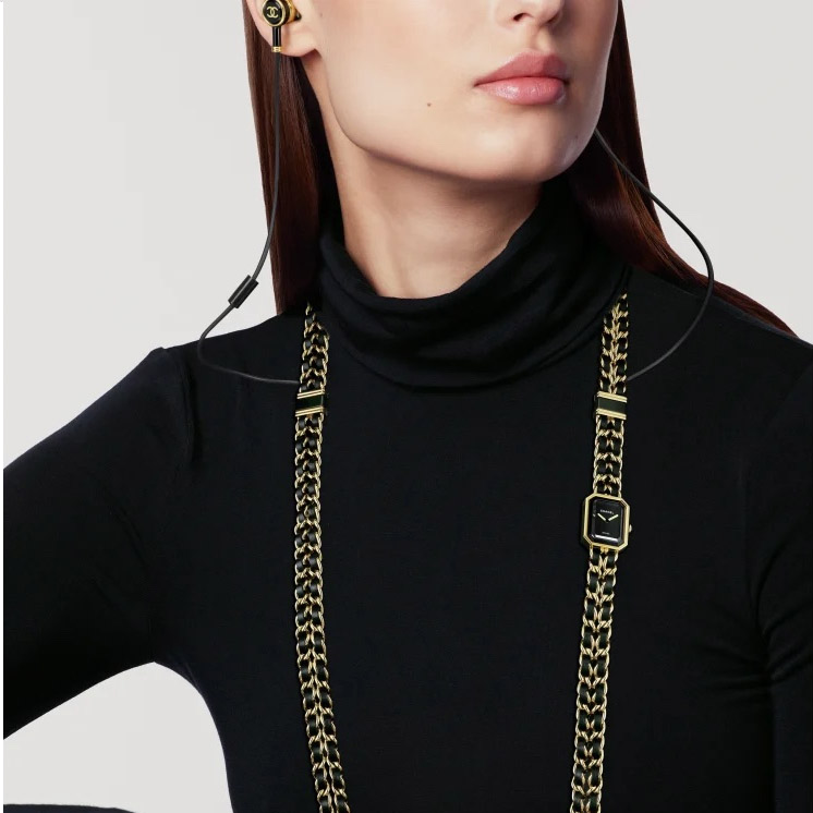 A model wearing the creation that combines a watch, necklace, and wired earphones