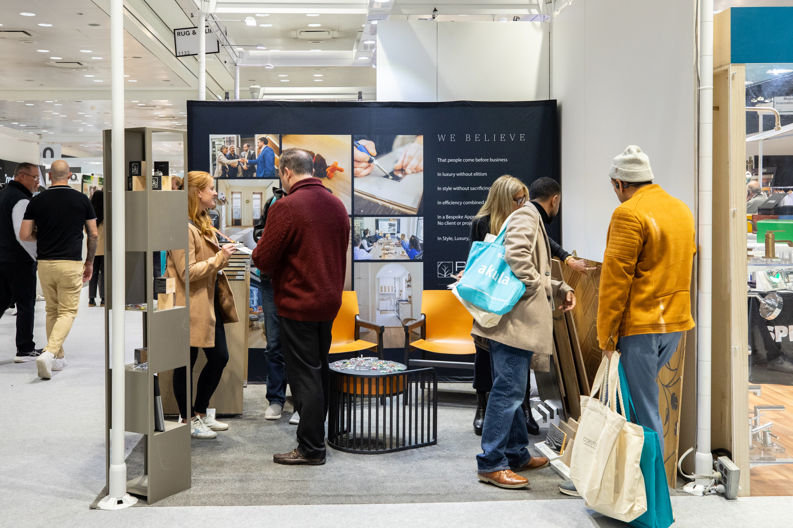 Industry networking at PID Floors BDNY 2025 booth with hospitality design professionals discussing luxury flooring trends and innovations