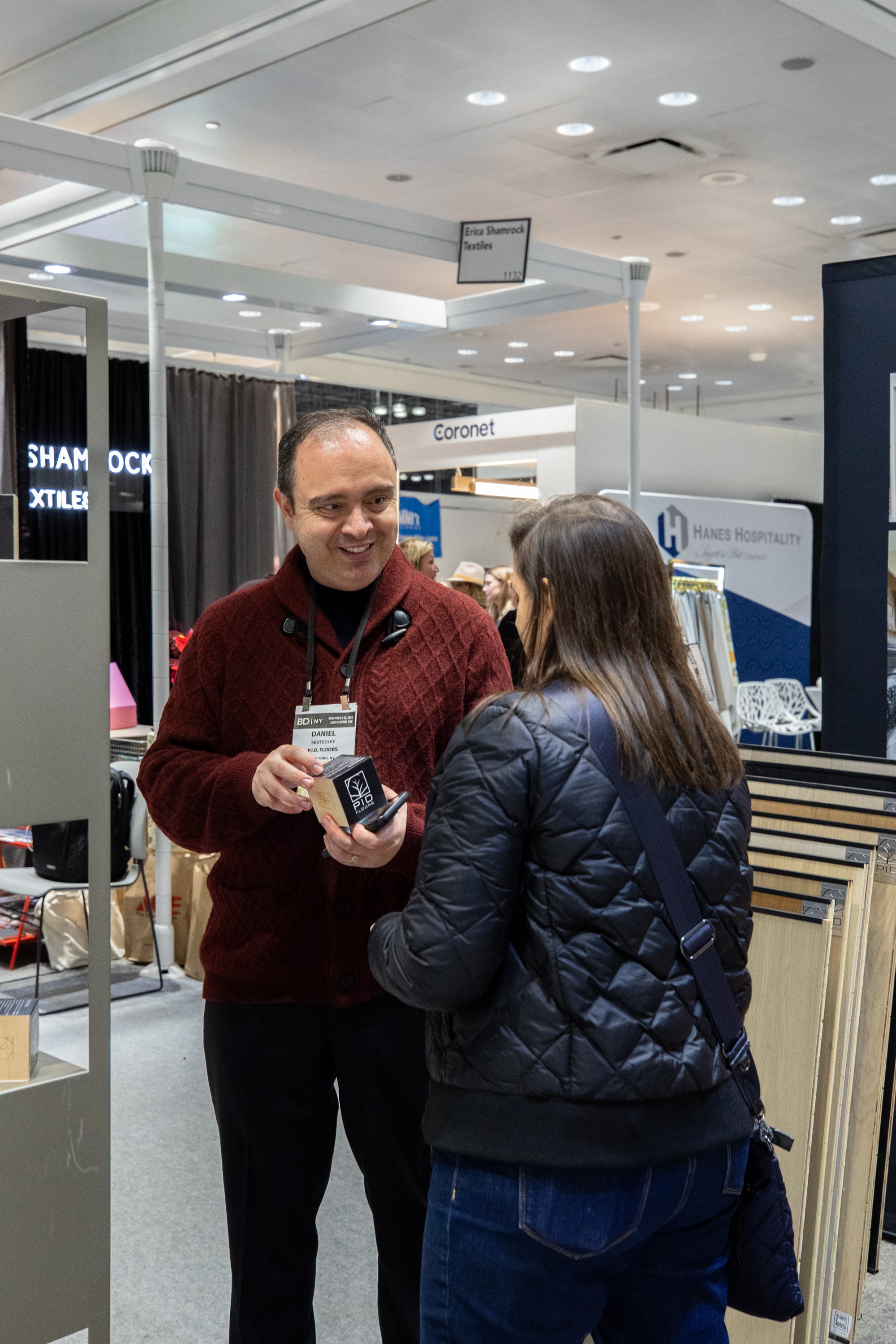 Interior designers and architects examining PID Floors luxury flooring samples at Boutique Design New York 2025 trade show booth