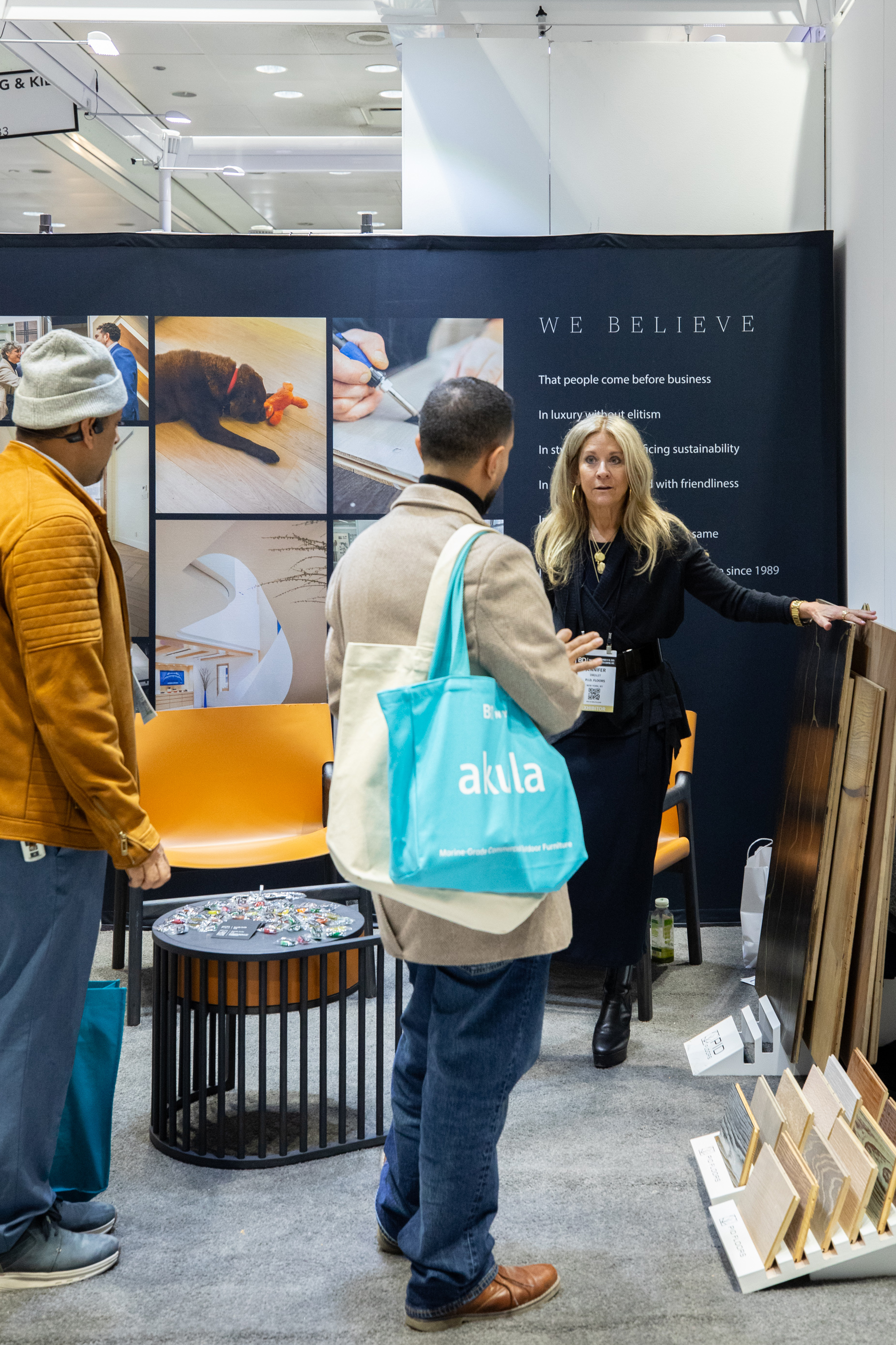 Hospitality design professionals reviewing PID Floors premium flooring portfolio at BDNY 2025 New York luxury surface exhibition