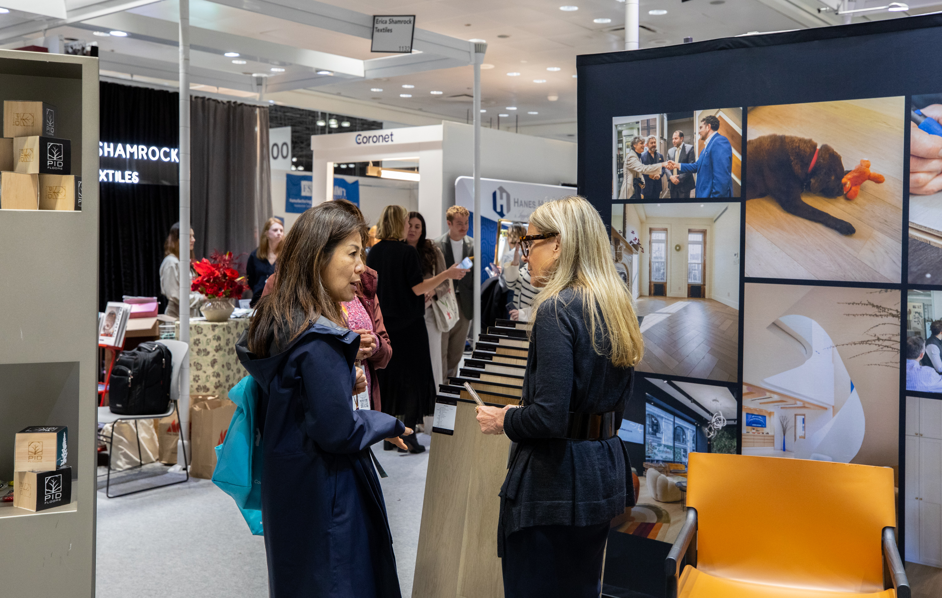Bustling PID Floors booth at BDNY 2025 finale showing engaged hospitality design community exploring luxury flooring innovations in New York
