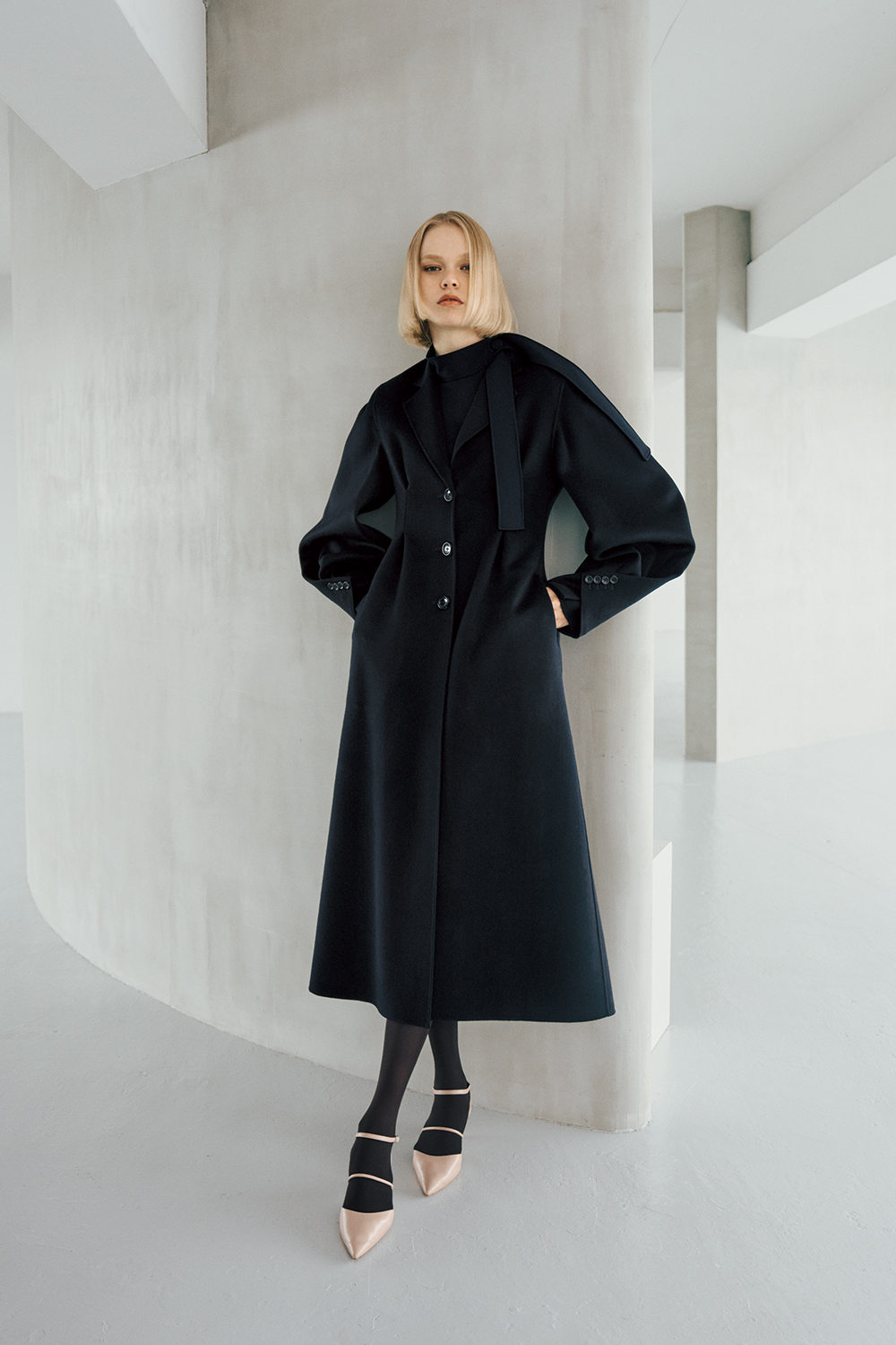 The model is wearing a black coat.