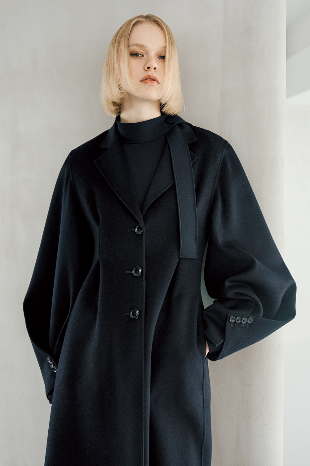 The model is wearing a black coat.