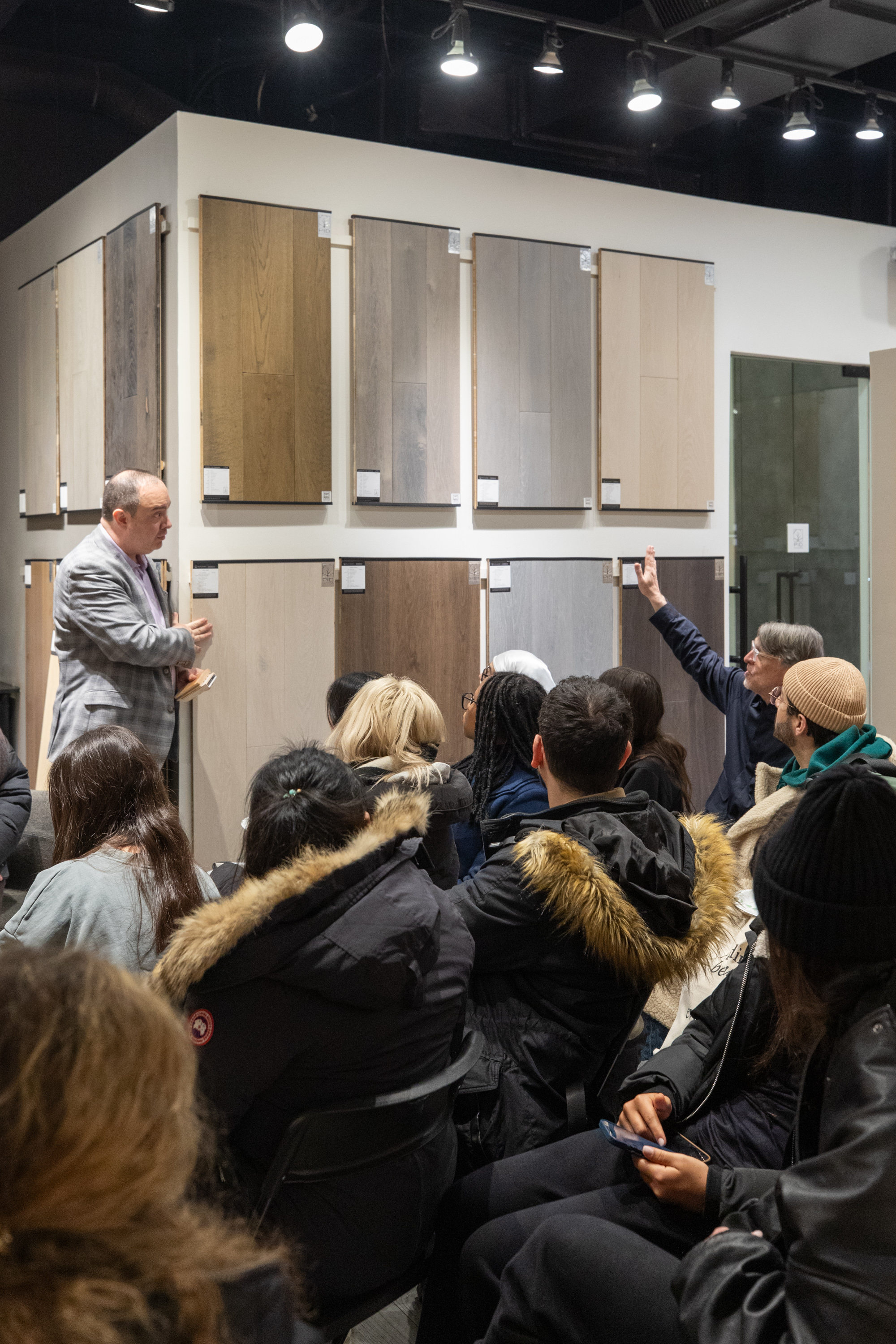 Fashion Institute of Technology students gathered around hardwood flooring material boards