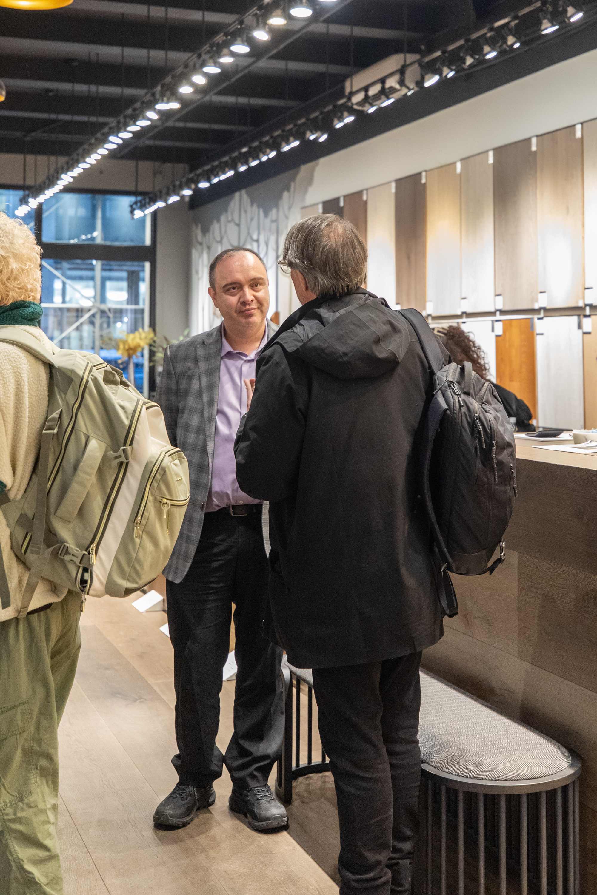 FIT student closely examining engineered hardwood flooring finish options at PID Floors