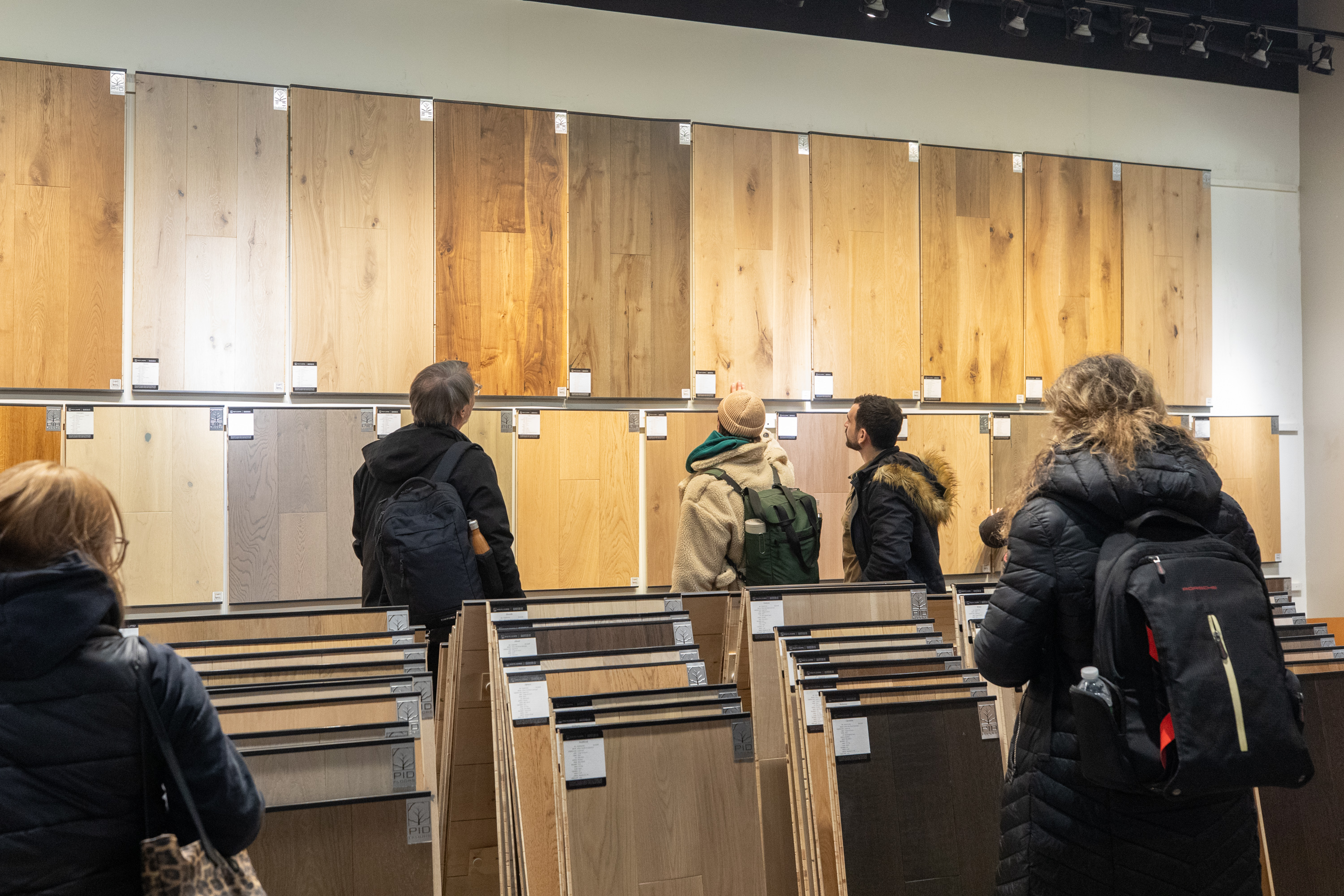 Group of FIT students engaged in hands-on luxury hardwood flooring exploration
