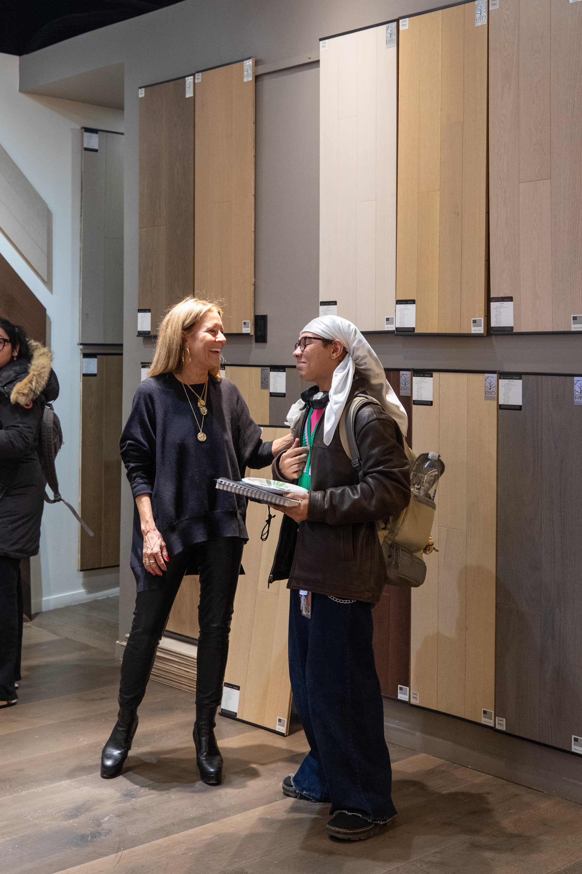 An educator from PID Floors gestures toward installation details on a hardwood floor