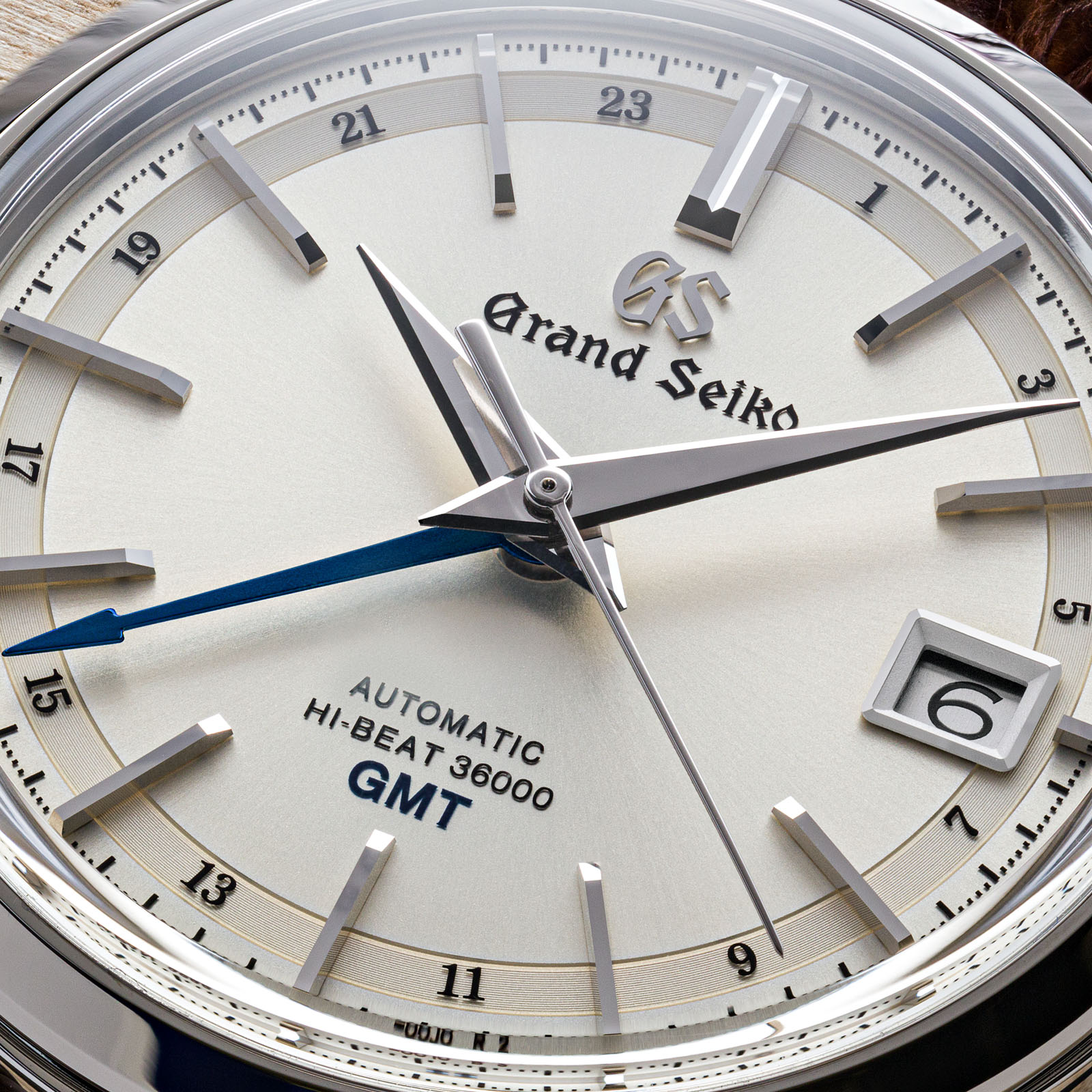A light dial watch in a classic case with a tempered-blue GMT hand. 