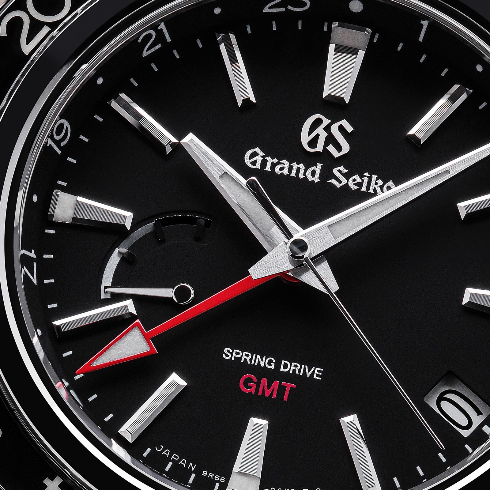 Grand Seiko SBGE201 - macro of a black bezel and dial with red accents. 