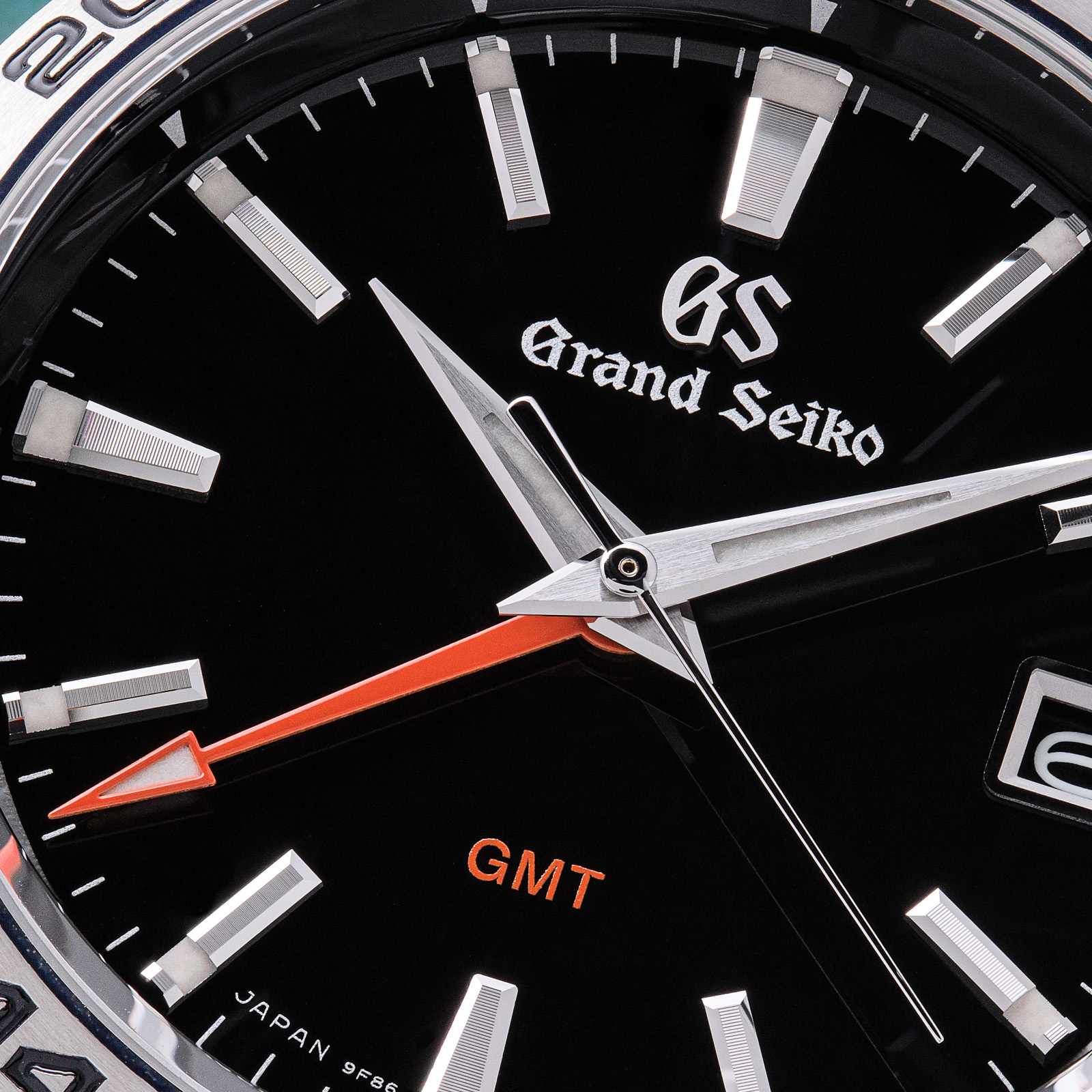 Grand Seiko SBGN003 - macro detail of black dial with red accents. 