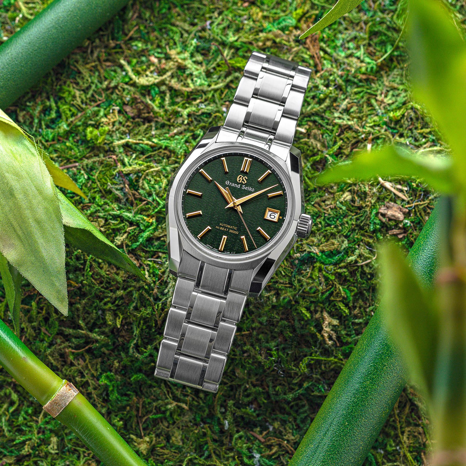 Green-dialed stainless steel wristwatch with gold-tone indexes and hands. 