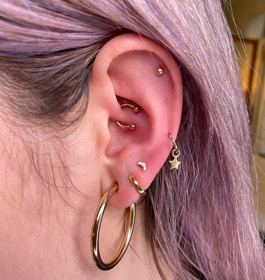 A close-up of a freshly pierced ear, with the person gently cleaning it with a saline solution to promote healthy healing.