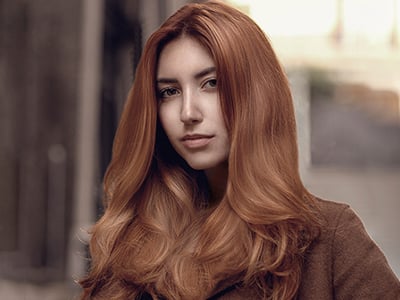 A women with long red hair looking at the camera