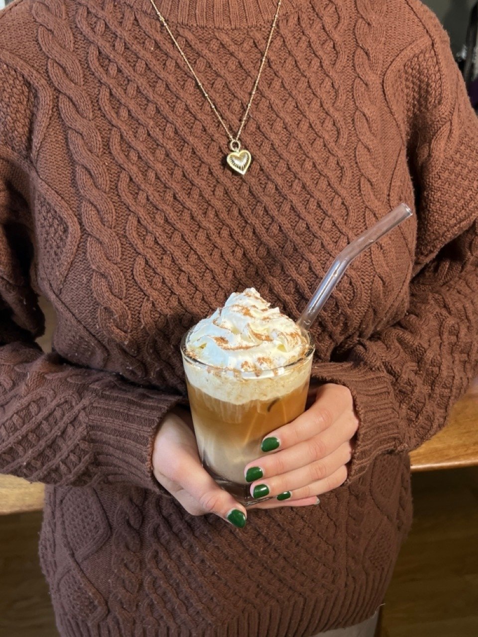 Woman holding completed Pumpkin Spice Latte in her hands