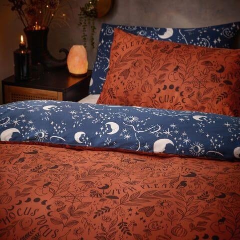 A closeup image of a an orange Halloween duvet cover set with a blue reverse, printed with a range of spooky imagery and slogans.