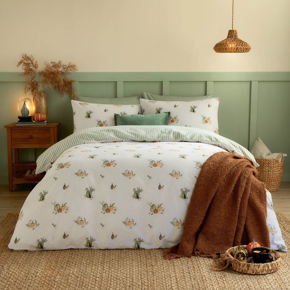 Reversible white and green pumpkin motif bed set with an orange throw